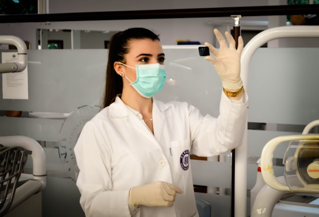 A nurse in a lab coat examining a medical device